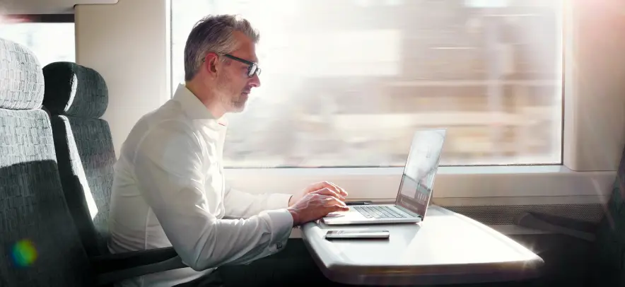 Man working on his computer while riding a train